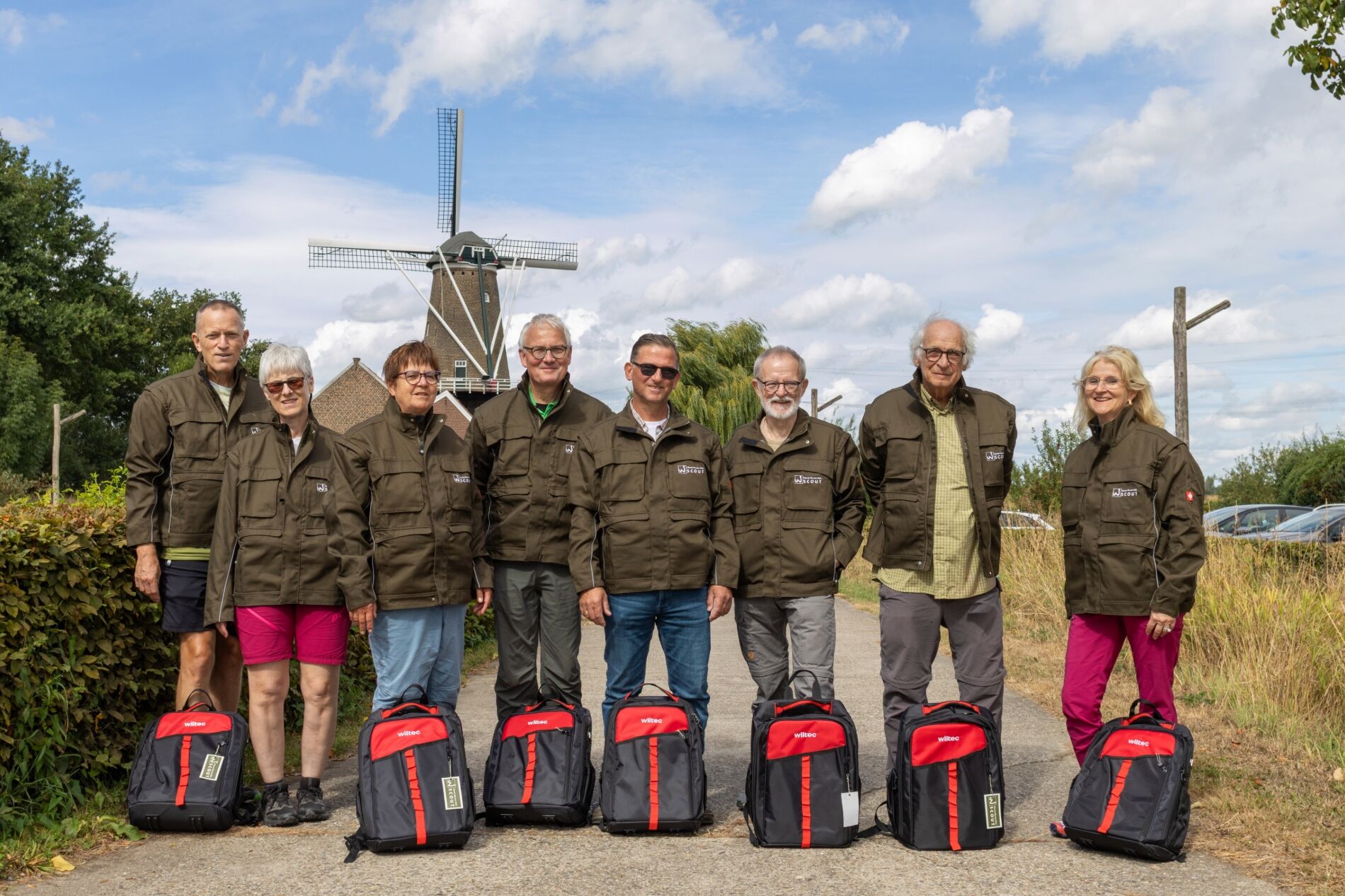 Die Wegescouts stehen mit neuen Rucksäcken und Jacken vor der Windmühle am Molenplas.