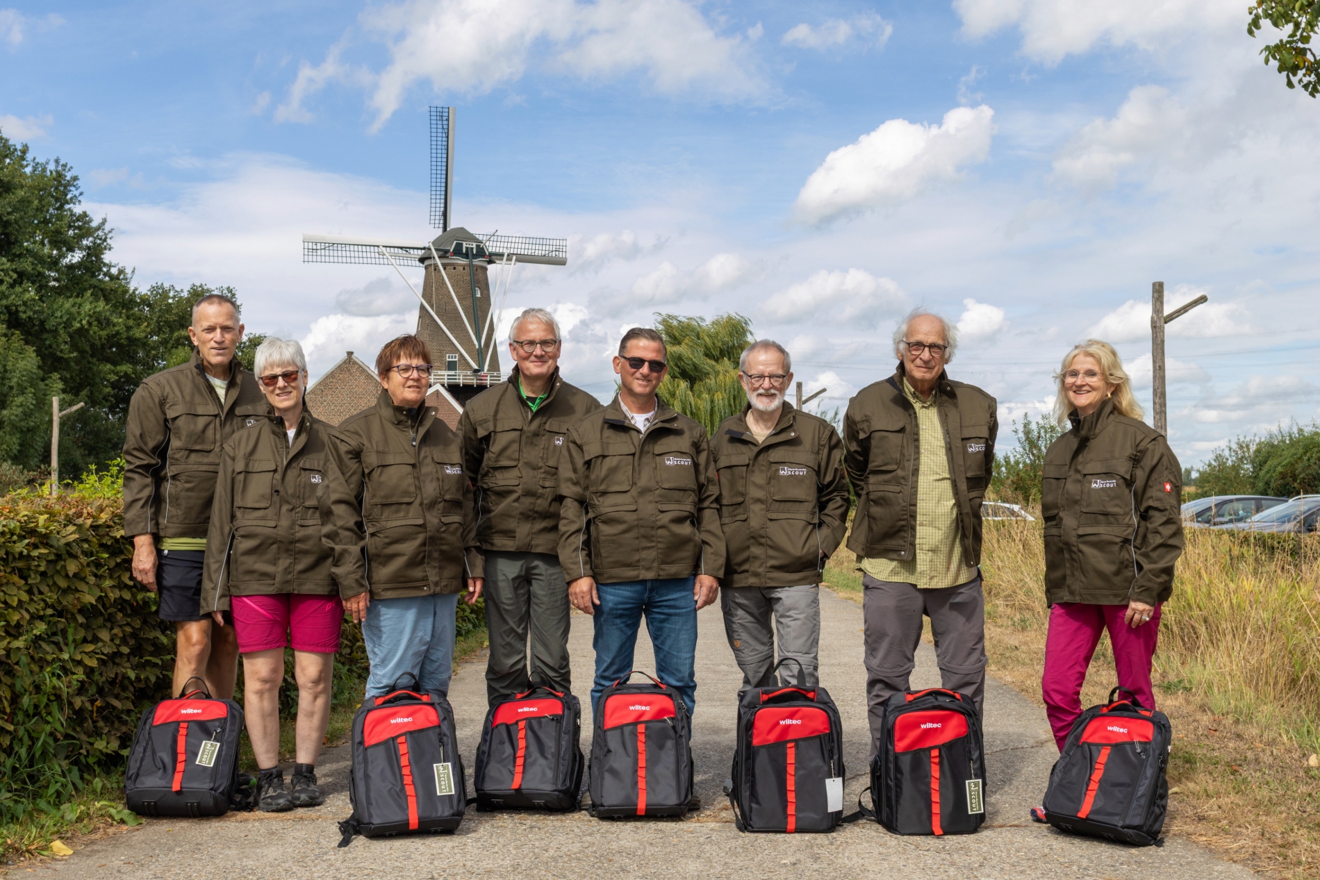 Die Wegescouts stehen mit neuen Rucksäcken und Jacken vor der Windmühle am Molenplas.